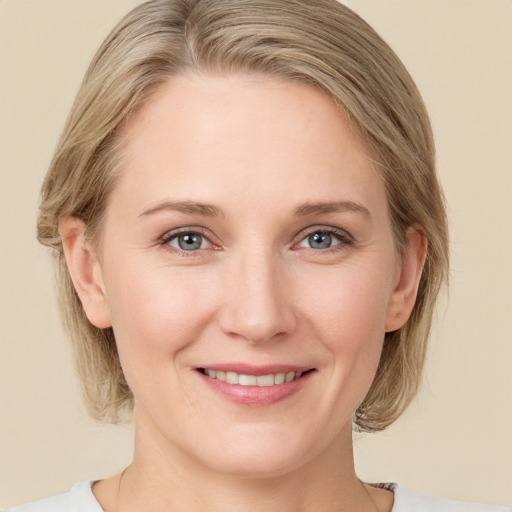 Joyful white young-adult female with medium  brown hair and blue eyes