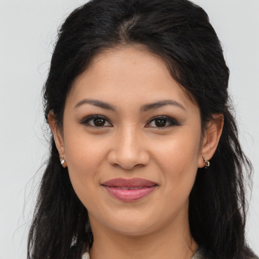 Joyful latino young-adult female with long  brown hair and brown eyes