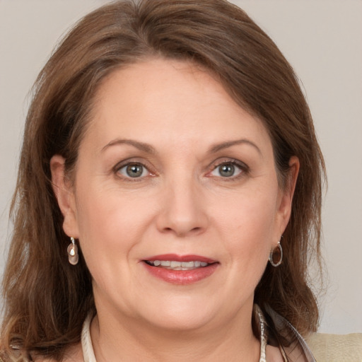 Joyful white adult female with medium  brown hair and grey eyes