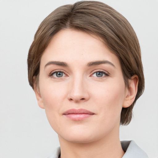 Joyful white young-adult female with short  brown hair and grey eyes