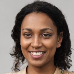 Joyful black young-adult female with long  brown hair and brown eyes