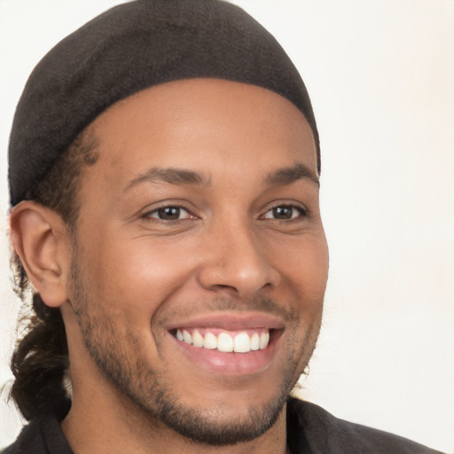 Joyful black young-adult male with short  brown hair and brown eyes