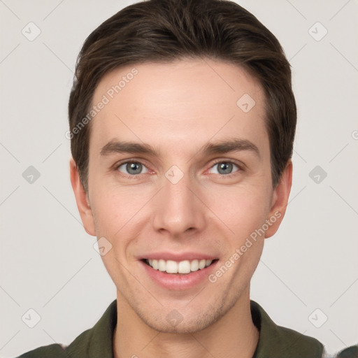 Joyful white young-adult male with short  brown hair and grey eyes