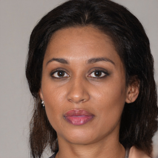 Joyful black young-adult female with medium  brown hair and brown eyes
