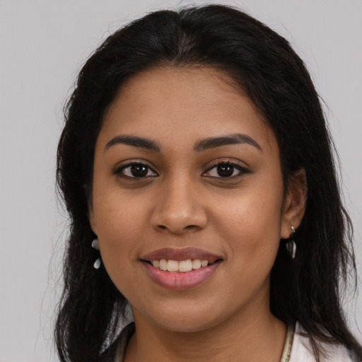 Joyful latino young-adult female with long  brown hair and brown eyes