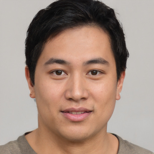 Joyful asian young-adult male with short  brown hair and brown eyes