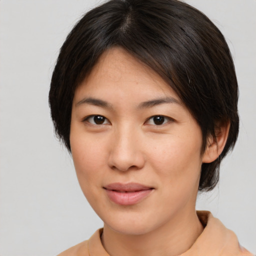 Joyful asian young-adult female with medium  brown hair and brown eyes