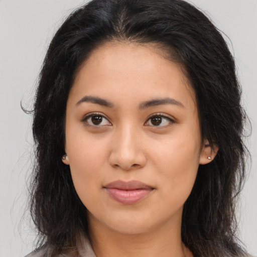 Joyful latino young-adult female with long  brown hair and brown eyes