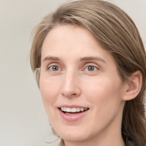 Joyful white young-adult female with long  brown hair and blue eyes