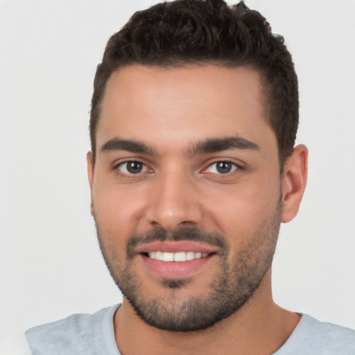 Joyful white young-adult male with short  black hair and brown eyes