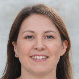 Joyful white adult female with long  brown hair and brown eyes