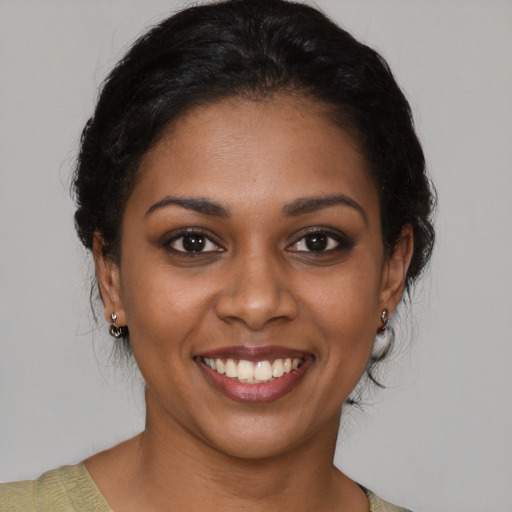 Joyful black young-adult female with medium  brown hair and brown eyes