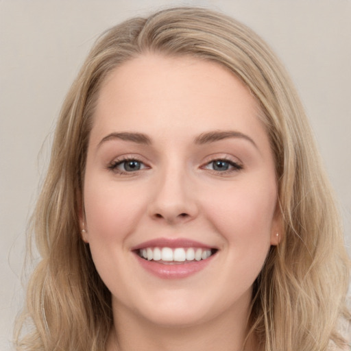 Joyful white young-adult female with long  brown hair and blue eyes