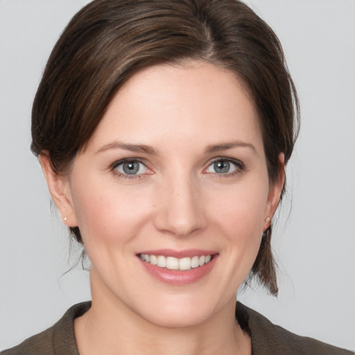 Joyful white young-adult female with medium  brown hair and grey eyes