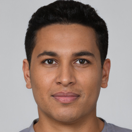 Joyful latino young-adult male with short  black hair and brown eyes