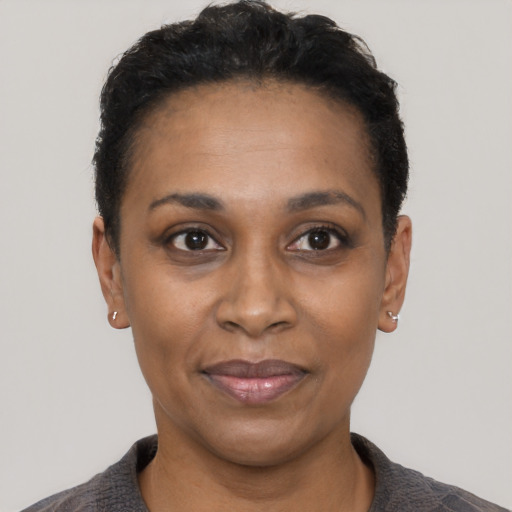 Joyful black adult female with short  black hair and brown eyes