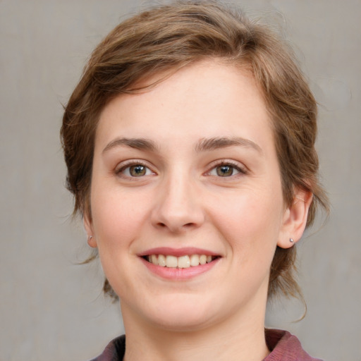 Joyful white young-adult female with medium  brown hair and grey eyes