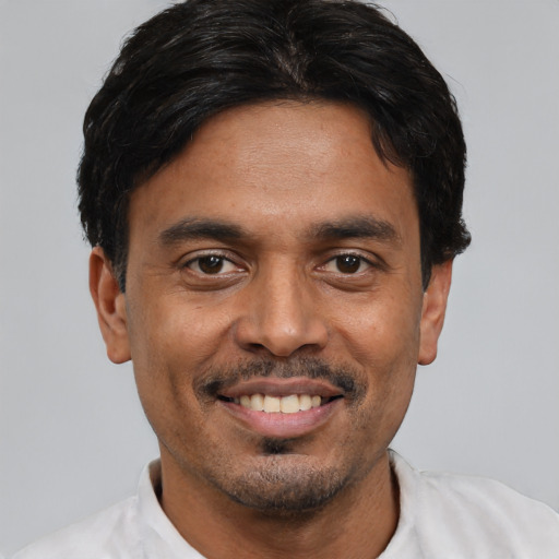 Joyful white young-adult male with short  black hair and brown eyes