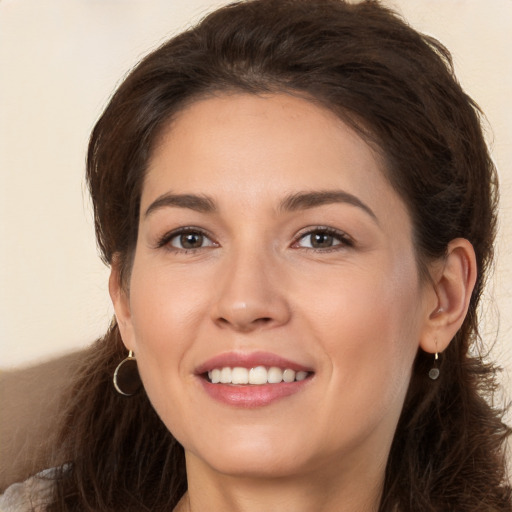 Joyful white young-adult female with long  brown hair and brown eyes