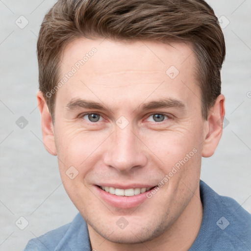 Joyful white young-adult male with short  brown hair and grey eyes