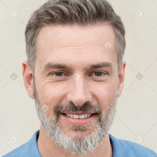 Joyful white adult male with short  brown hair and grey eyes