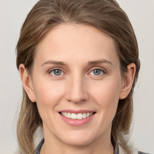 Joyful white young-adult female with medium  brown hair and grey eyes