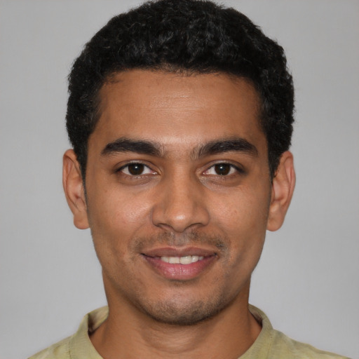 Joyful latino young-adult male with short  black hair and brown eyes