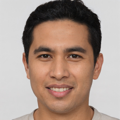 Joyful asian young-adult male with short  black hair and brown eyes