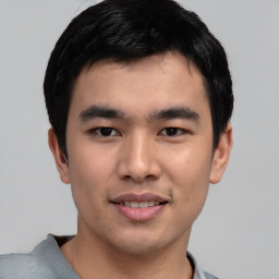 Joyful asian young-adult male with short  black hair and brown eyes