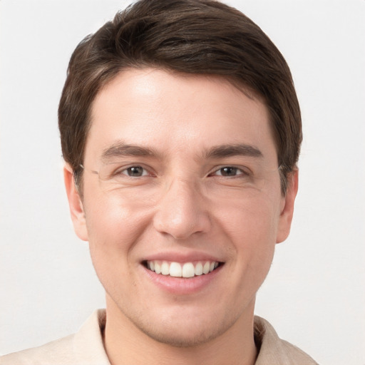 Joyful white young-adult male with short  brown hair and grey eyes