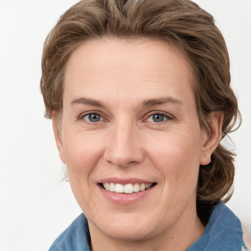 Joyful white adult female with medium  brown hair and grey eyes