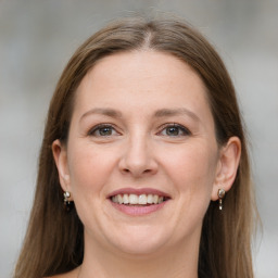 Joyful white adult female with long  brown hair and grey eyes