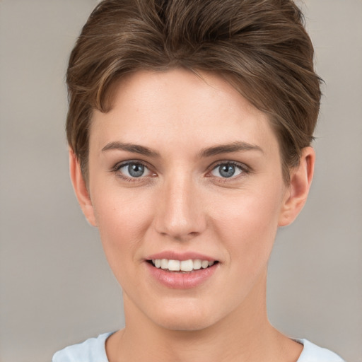 Joyful white young-adult female with short  brown hair and grey eyes