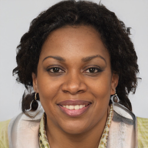 Joyful black adult female with medium  brown hair and brown eyes
