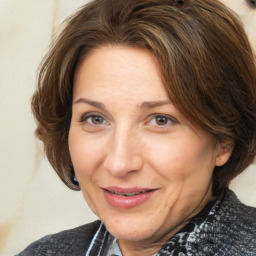 Joyful white adult female with medium  brown hair and brown eyes