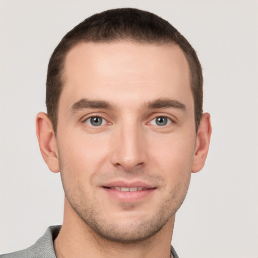 Joyful white young-adult male with short  brown hair and grey eyes