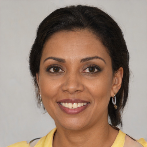 Joyful latino young-adult female with medium  brown hair and brown eyes