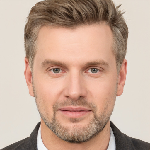 Joyful white adult male with short  brown hair and grey eyes