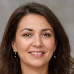 Joyful white adult female with long  brown hair and brown eyes