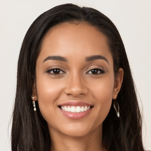 Joyful latino young-adult female with long  brown hair and brown eyes