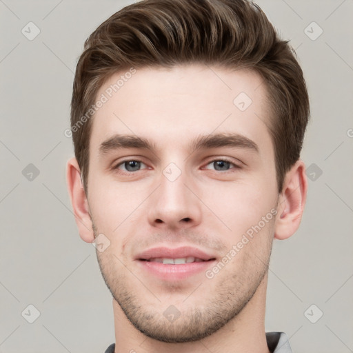 Joyful white young-adult male with short  brown hair and grey eyes