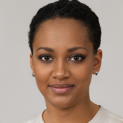 Joyful black young-adult female with short  black hair and brown eyes