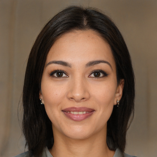 Joyful latino young-adult female with medium  brown hair and brown eyes