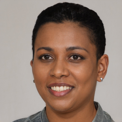 Joyful black young-adult female with short  black hair and brown eyes