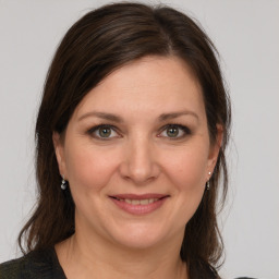 Joyful white young-adult female with medium  brown hair and grey eyes