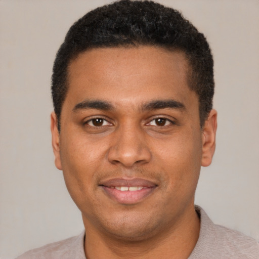 Joyful black young-adult male with short  black hair and brown eyes