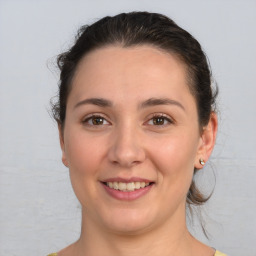 Joyful white young-adult female with medium  brown hair and brown eyes