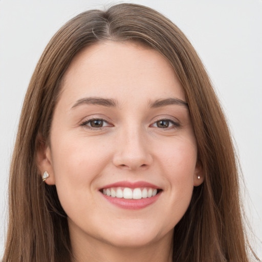 Joyful white young-adult female with long  brown hair and grey eyes