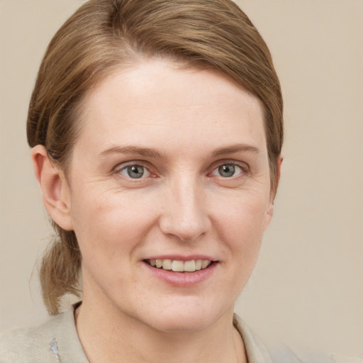 Joyful white young-adult female with short  brown hair and grey eyes