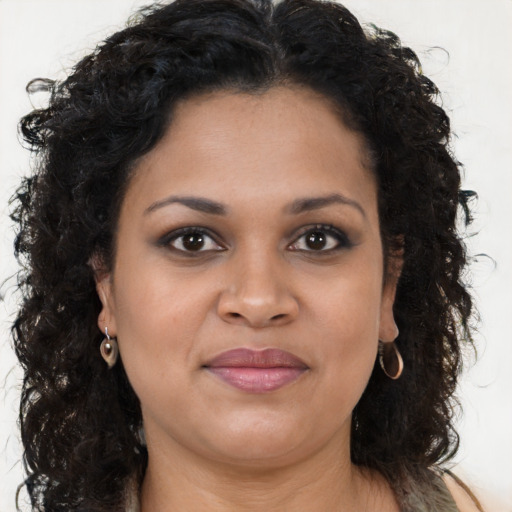 Joyful black young-adult female with long  brown hair and brown eyes